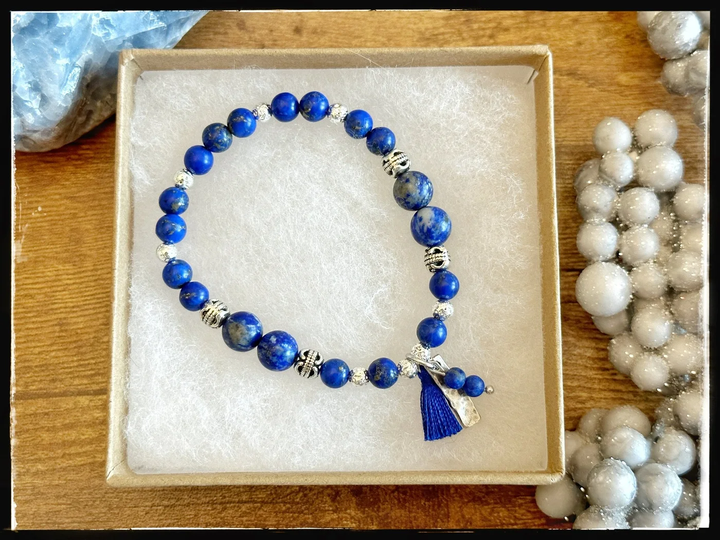 Blue beaded bracelet with a blue tassel and silver-tone charm