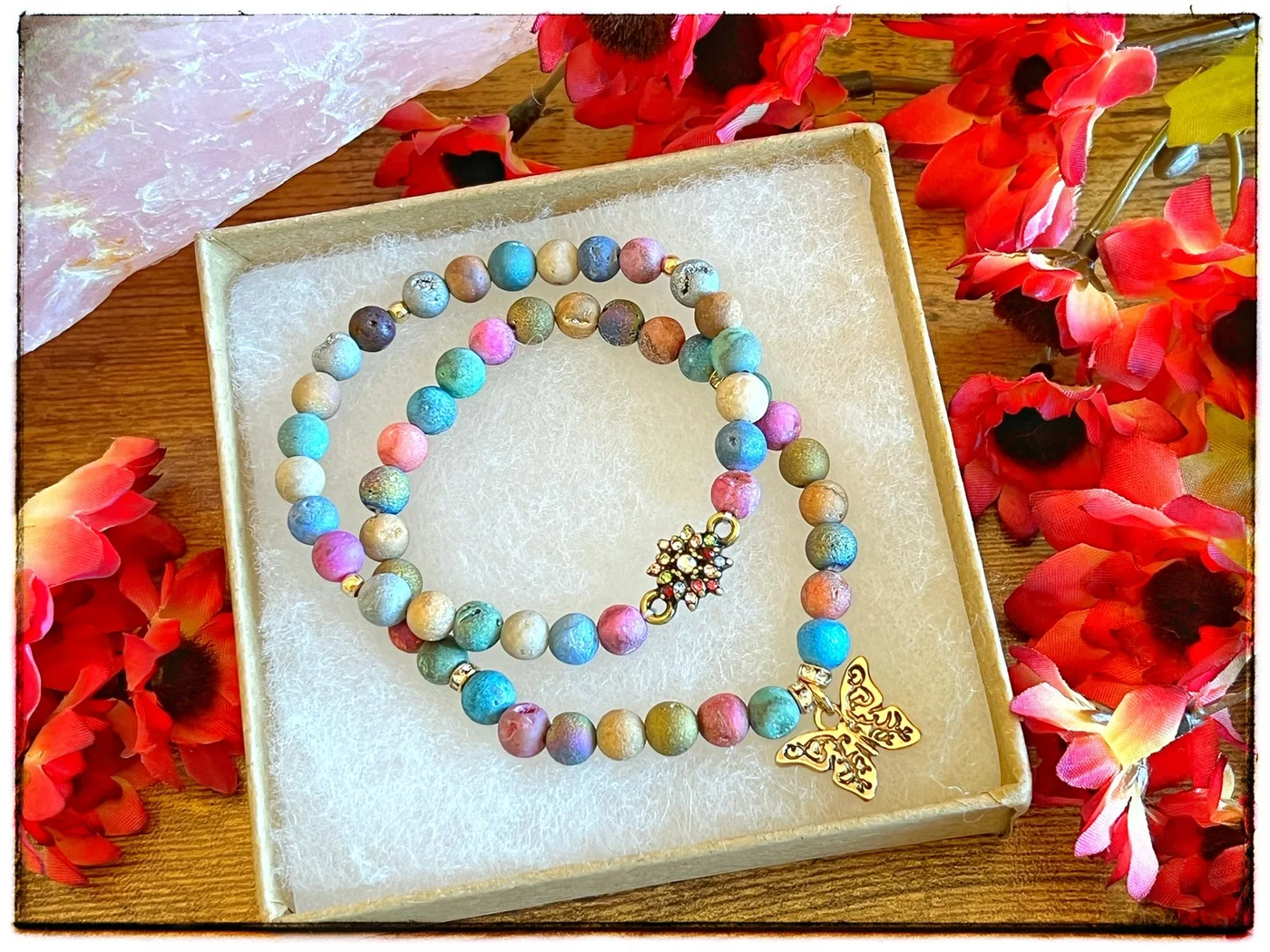 Two colorful beaded charm bracelets arranged in a gift box