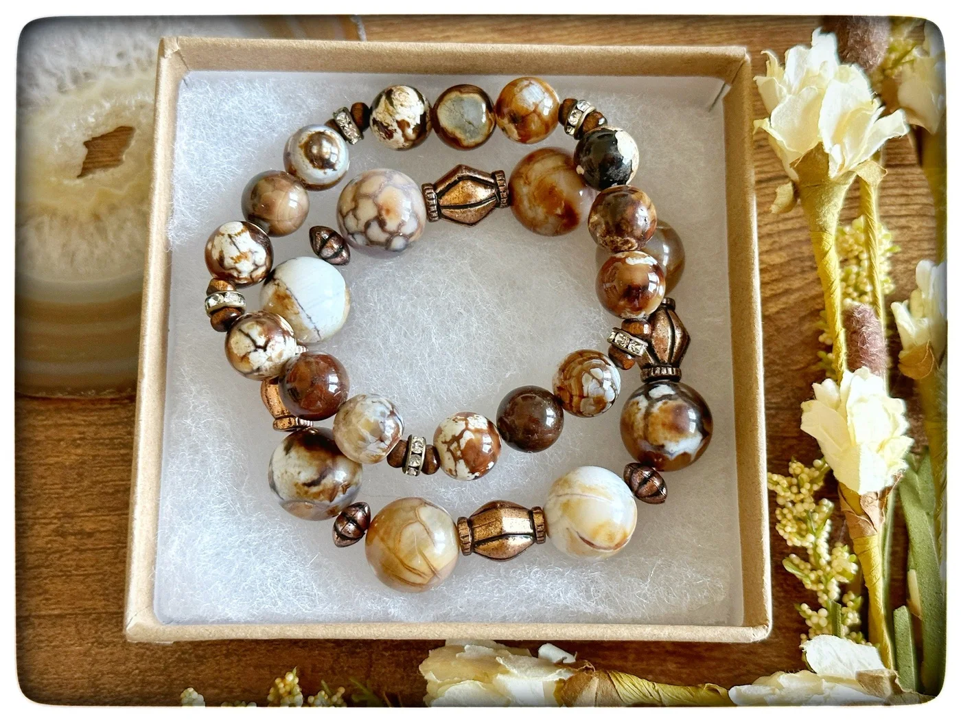 Brown, gold, cream, and clear beaded bracelet in a gift box