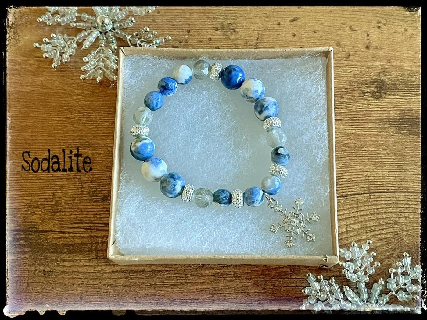 Blue and white sodalite bracelet beside a snowflake decoration